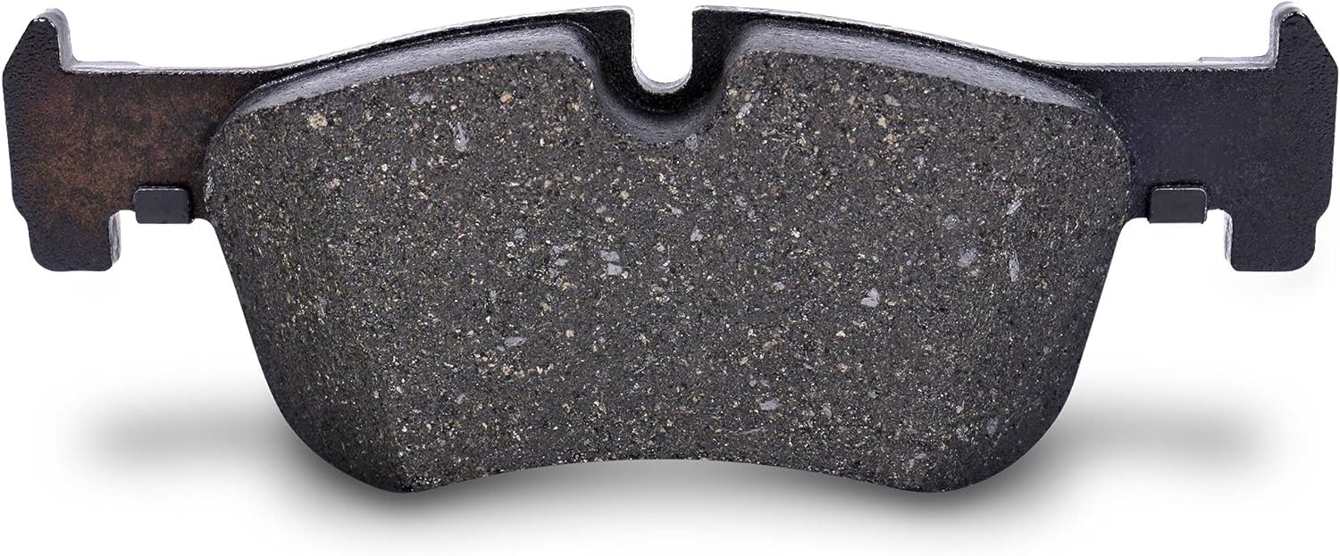 Close-up of a semi-metallic brake pad's coarse, steel-flecked friction material